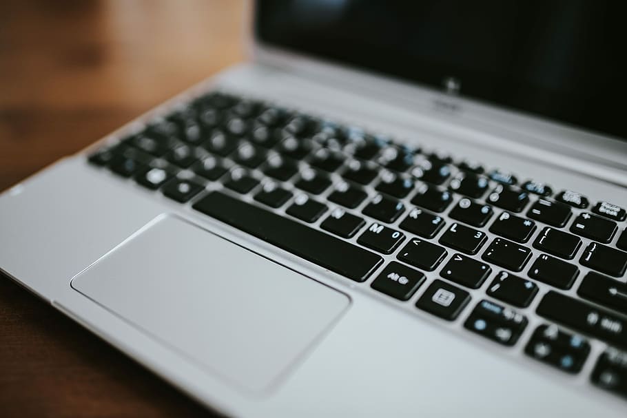 Silver laptop with various items on a table, magazines, computer HD wallpaper