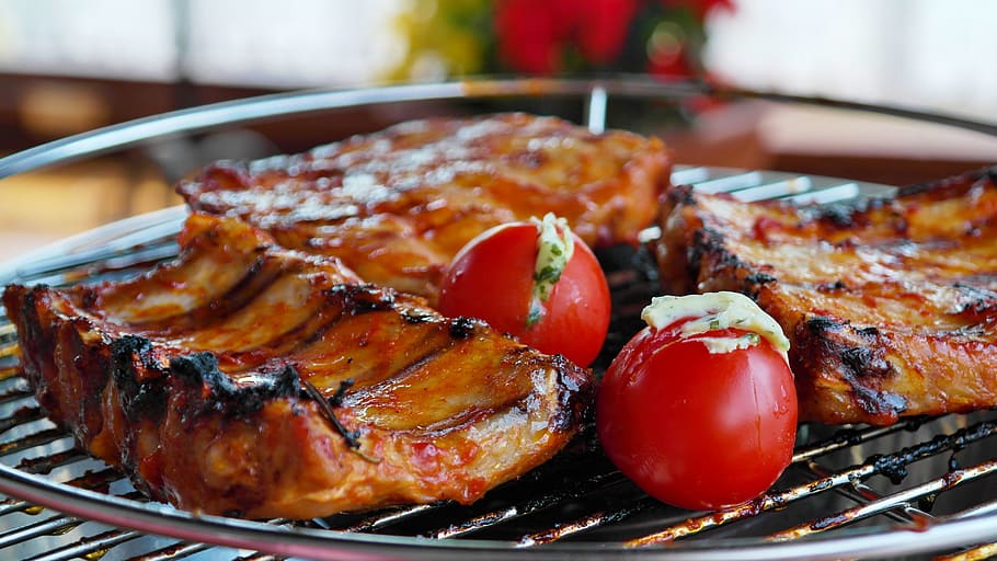baby back ribs grilled on grilling tray with red tomatoes, spare ribs