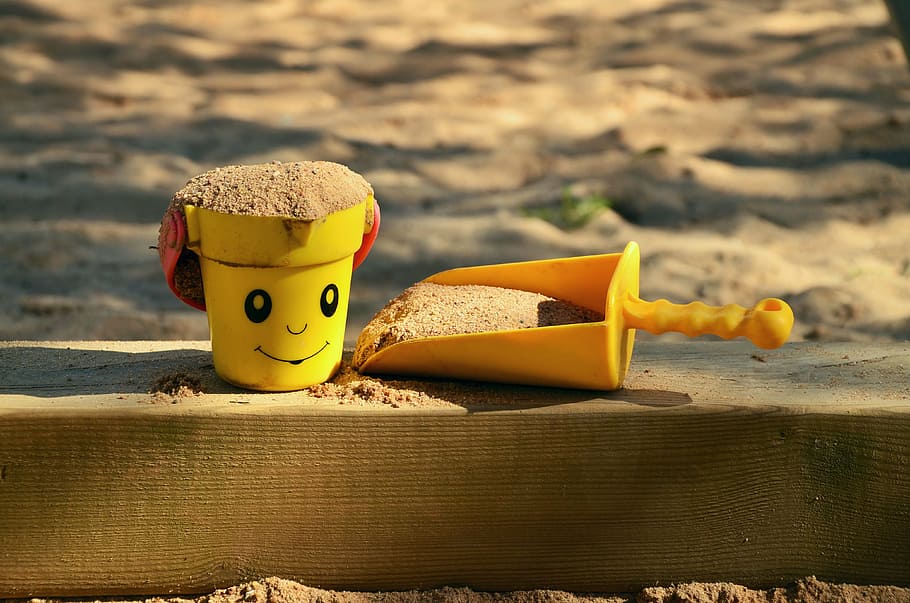 yellow bucket and trowel toys, sand pit, children's playground