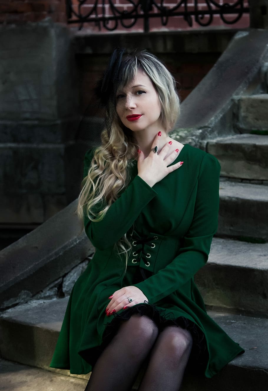 woman in green long-sleeved dress sitting and posing on concrete stairs HD wallpaper
