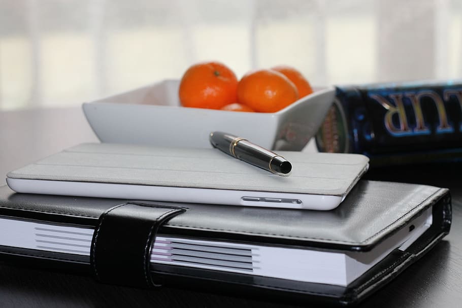 white Android smartphone on top of black leather book binder HD wallpaper