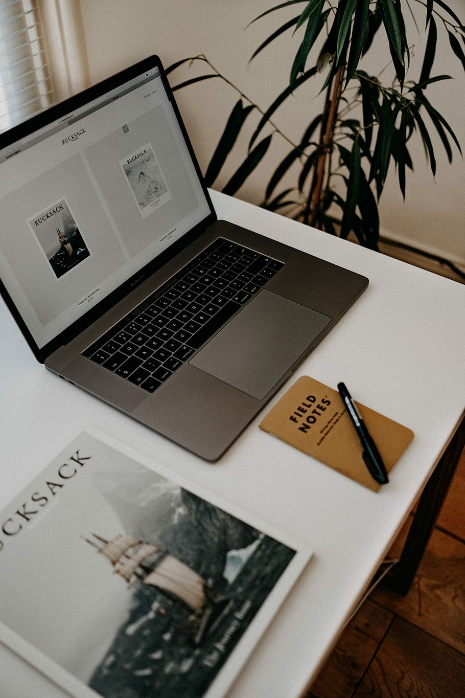 MacBook Pro on white table, black pen near black and grey laptop on white desk HD wallpaper