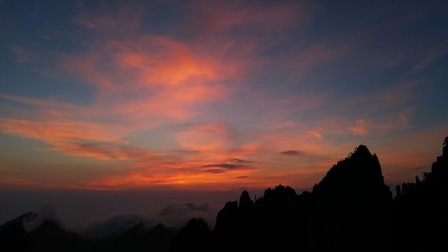 silhouette of mountain under orange and blue sky during sunset HD wallpaper