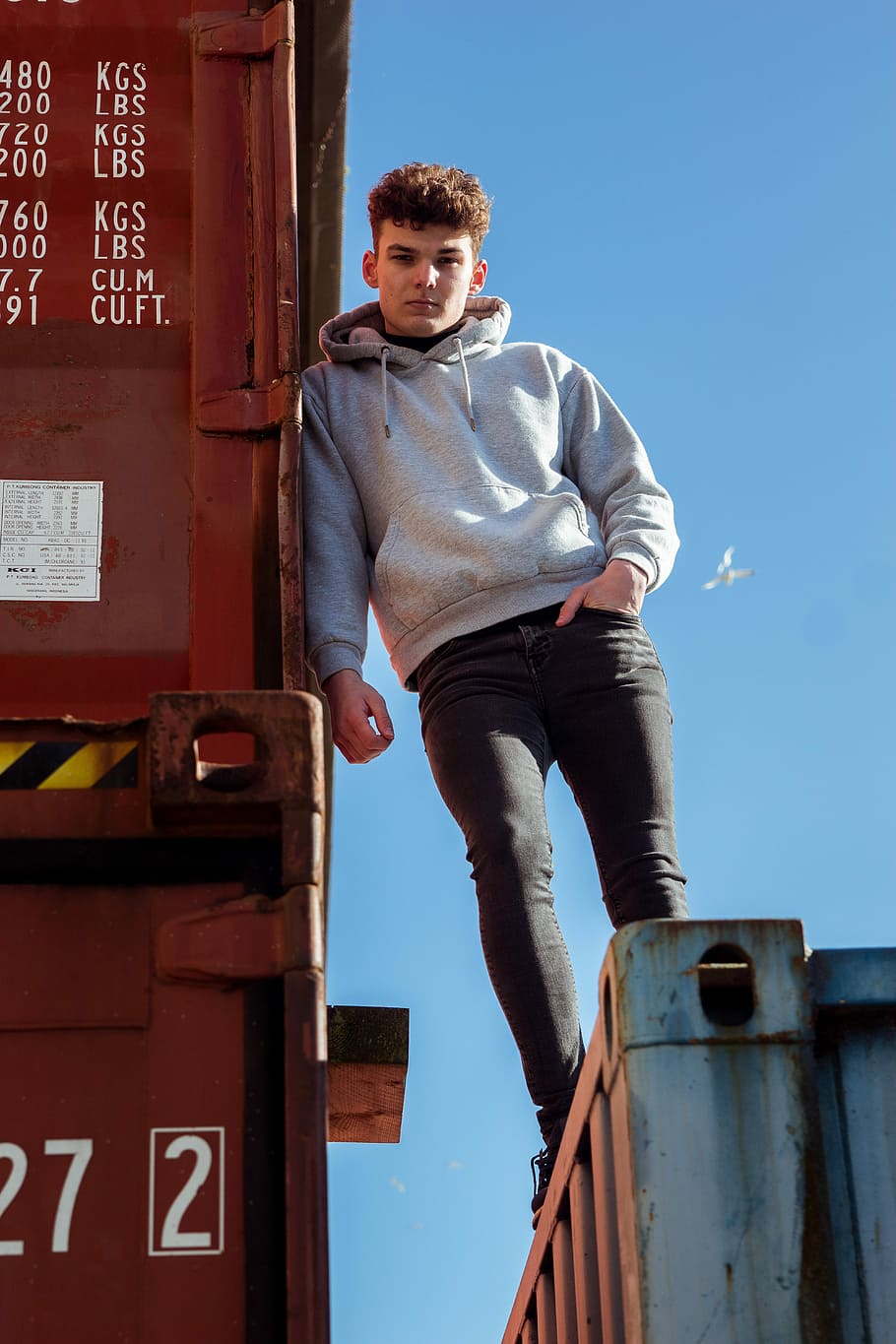 man standing on trailer, container, looking down, young man HD wallpaper
