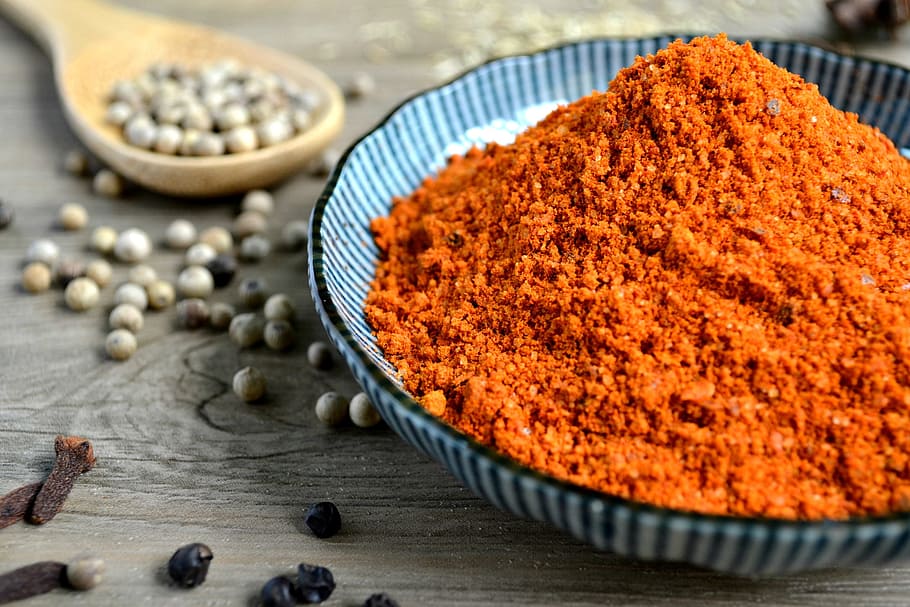 red spices on blue bowl with peppers scattered on table, orange powder on black and gray ceramic bowl, HD wallpaper