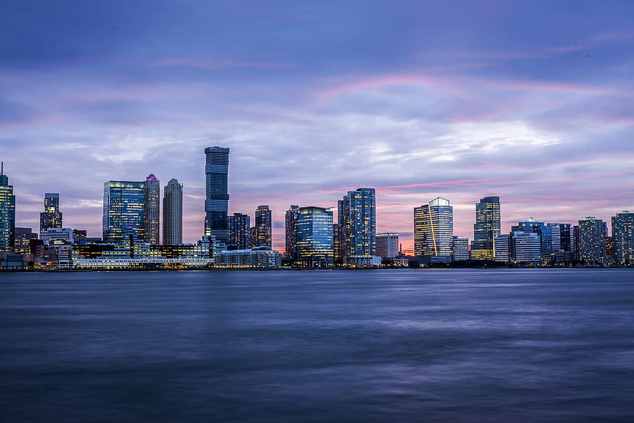 city buildings during sunset, city scapes near sea at daytime