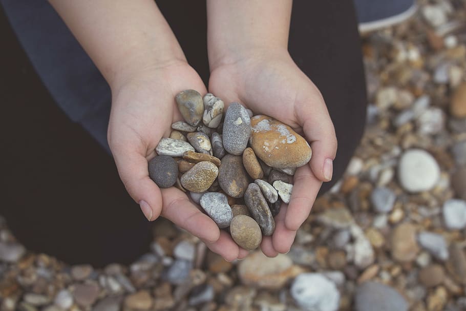 person holding gray and brown pebbles, stones, rocks, hands HD wallpaper
