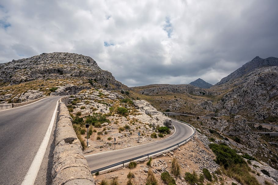 road near mountains under clouds, gray asphalt road near mountains HD wallpaper
