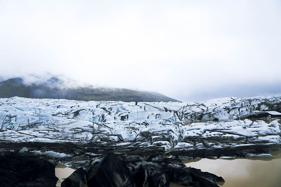 snow covered rocky field near body of water during daytime, photo of ice near body of water HD wallpaper