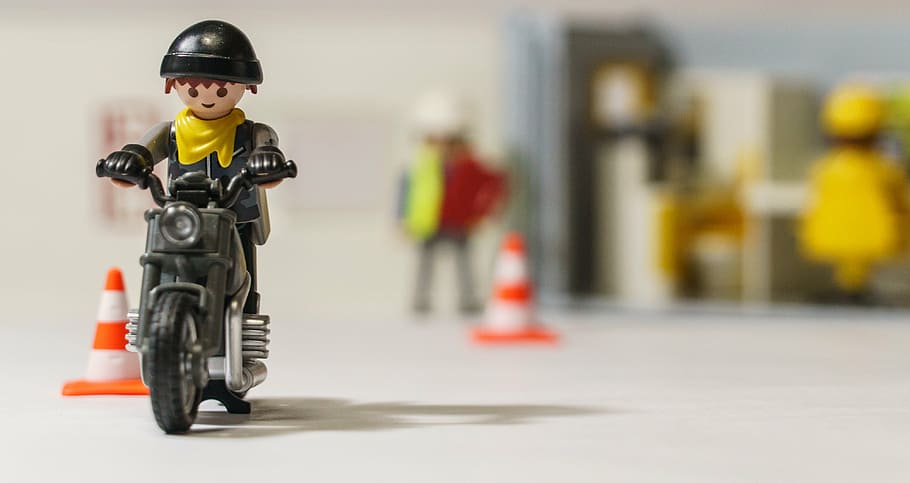selective focus photography of man riding motorcycle toy, playmobil