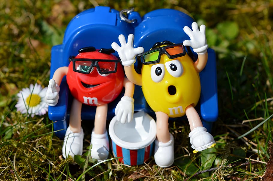 yellow and red M&M plastic toy on green grass field, m m's HD wallpaper