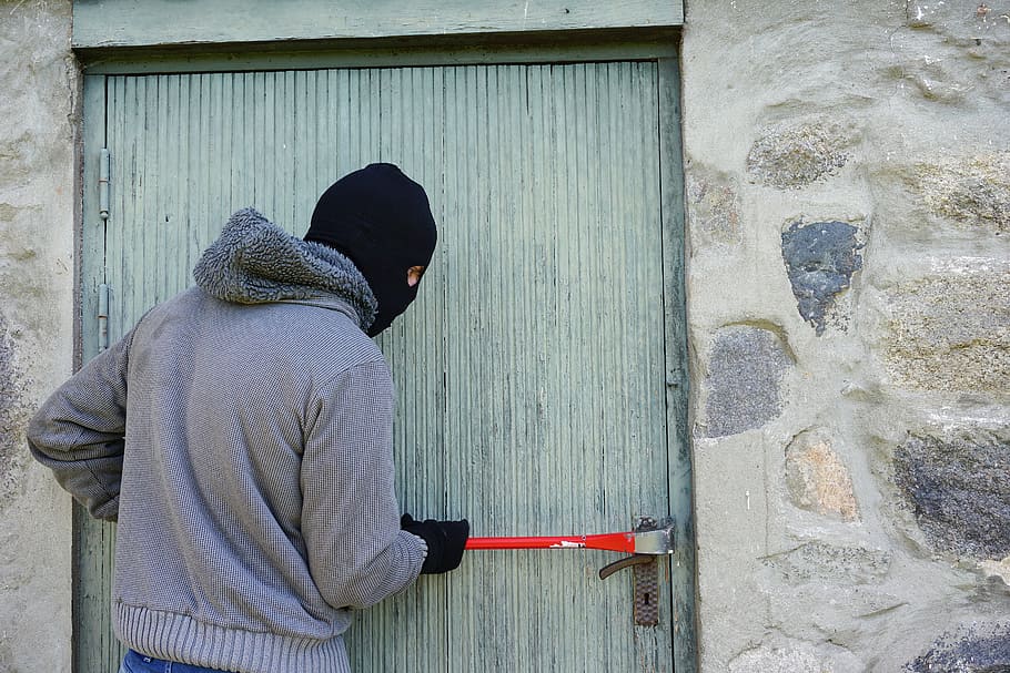 man wearing grey zip-up jacket holding red hand tool beside door, HD wallpaper