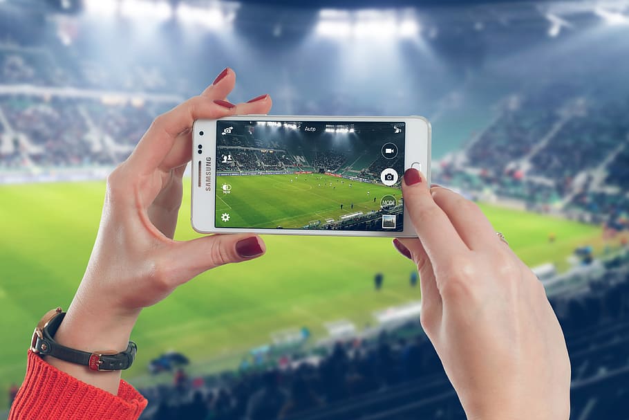 Woman photographer taking photo with mobile smartphone in stadium of soccer match, HD wallpaper