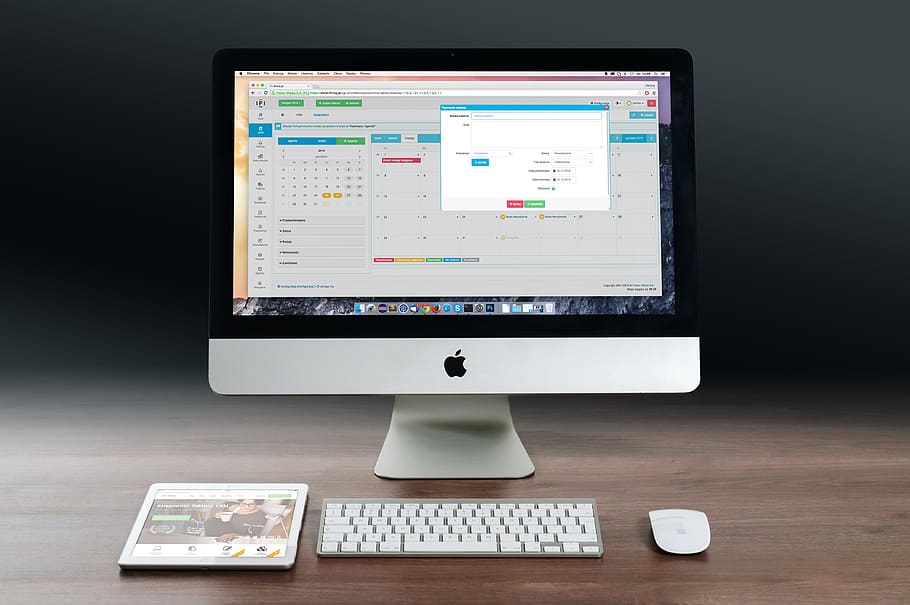 silver iMac, Apple Magic Mouse, Apple Wireless Keyboard and white iPad on brown desk HD wallpaper