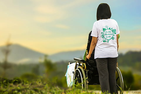 woman in white t-shirt holding black self-propelled wheelchair HD wallpaper