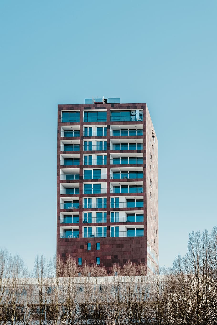 brown and blue concrete building, minimalist photography of high-rise building under calm blue sky HD wallpaper