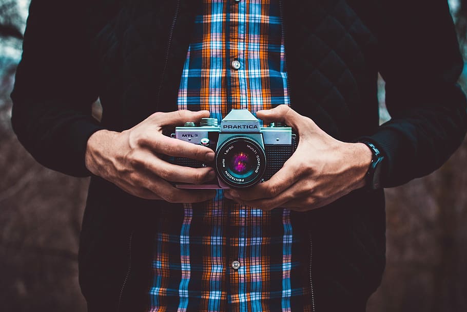 person holding mirrorless camera, person holding camera, film