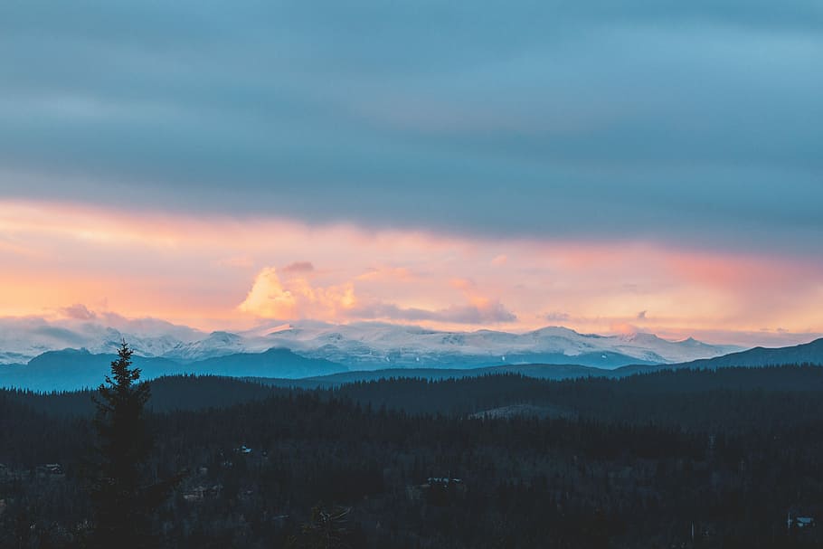 aerial photography of city under golden hour, skyline photography of mountain with trees under cloudy sky HD wallpaper