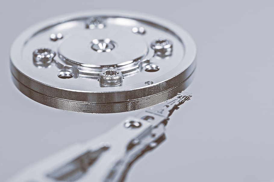 round silver metal component with screws, hard drive, detail