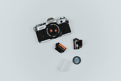 gray Canon film camera beside two black films, lens, accessory HD wallpaper