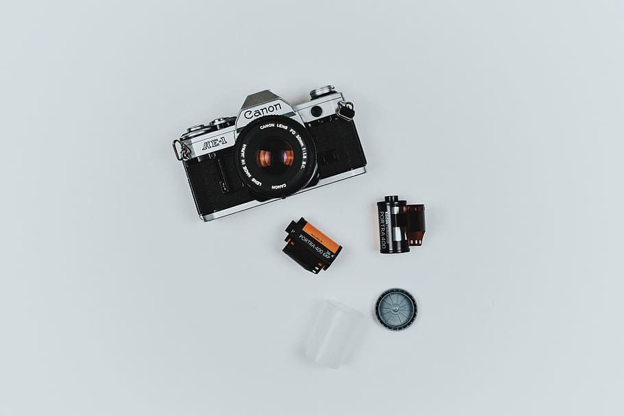 gray Canon film camera beside two black films, lens, accessory HD wallpaper