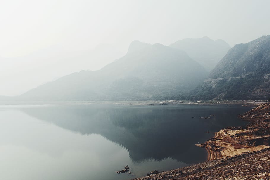 mirror photography of mountain under white clouds, landscape photo of calm lake near mountain at daytime HD wallpaper