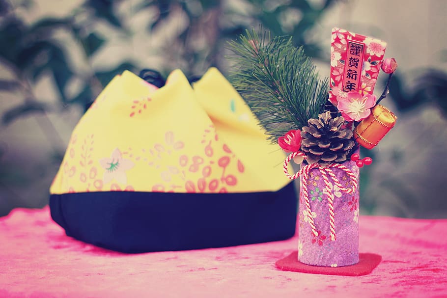 pink cylindrical case with pine cone beside yellow and black bag HD wallpaper