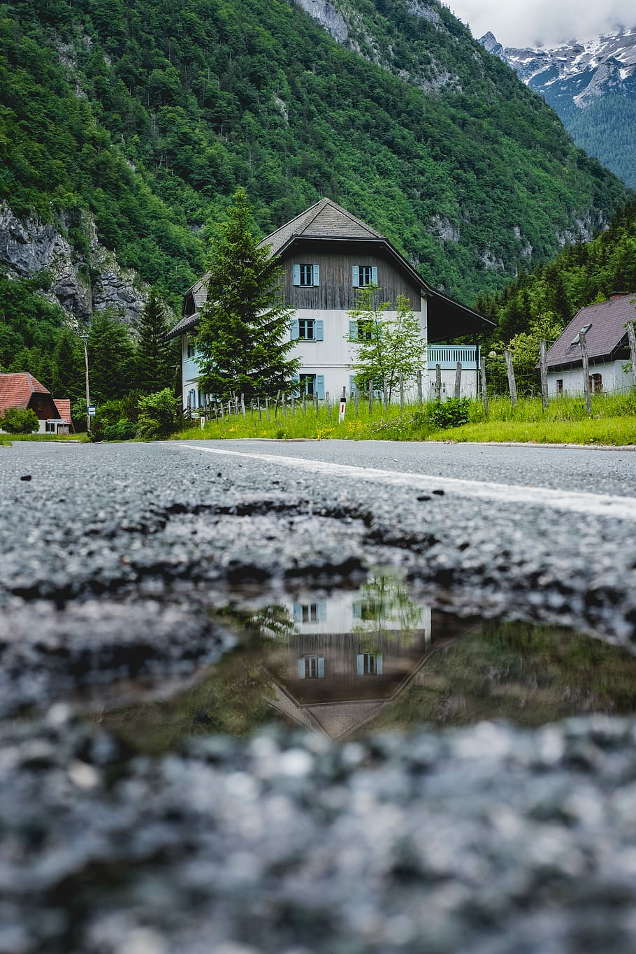 Road reflection of a Slovenian house, white and gray house near green mountain HD wallpaper