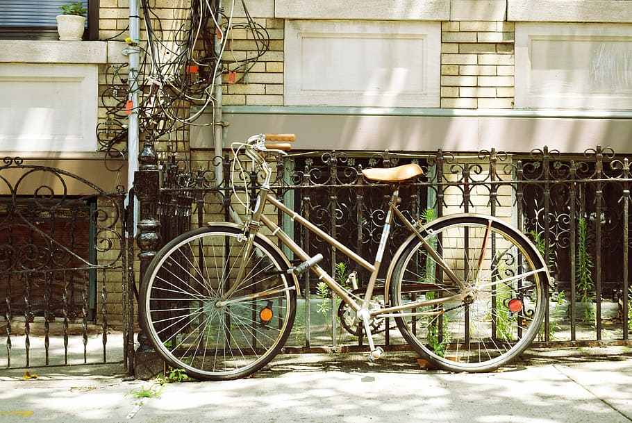 brown city bicycle beside of metal fence, brown bicycle parked on sidewalk leaning on black steel fence, HD wallpaper