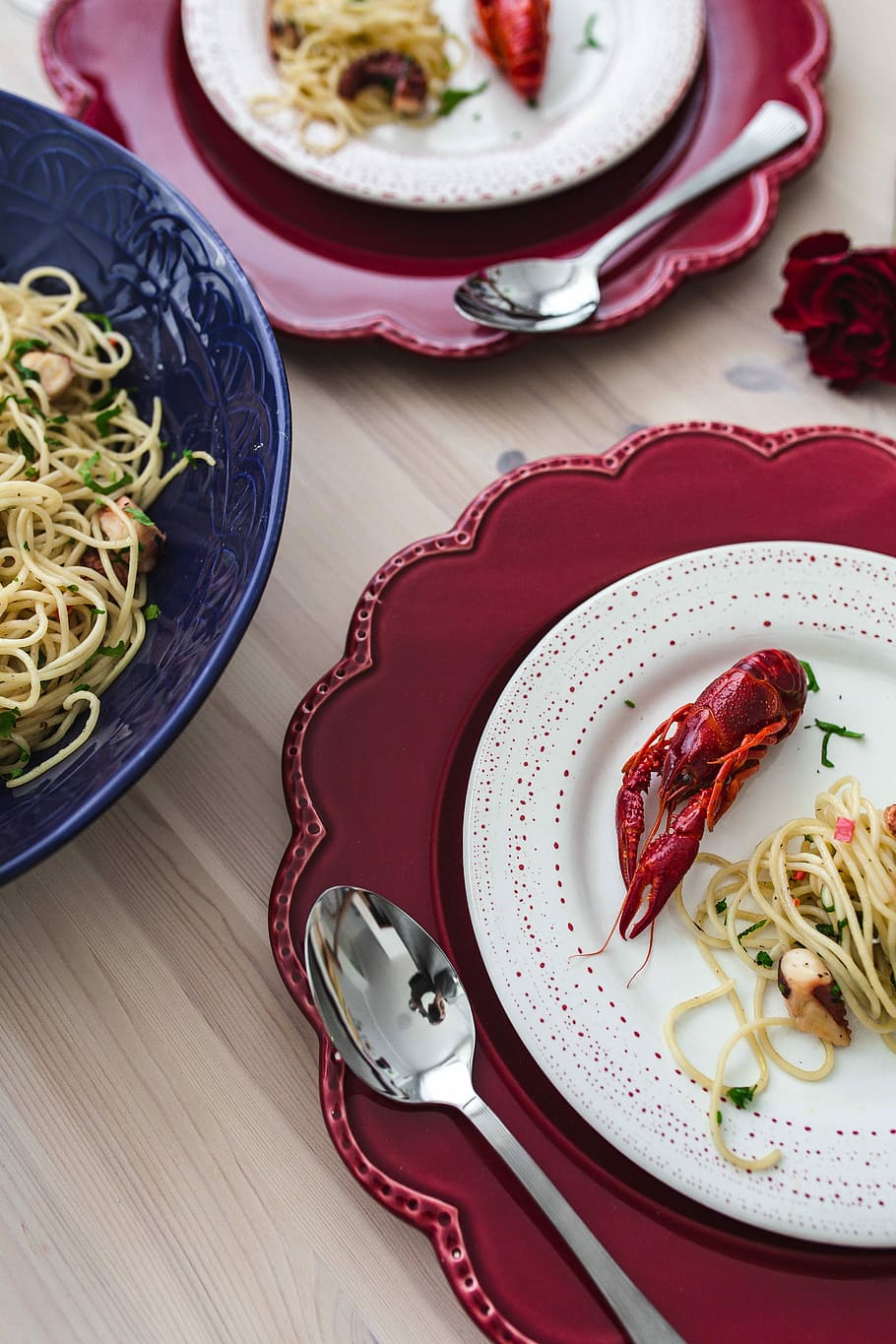 Fancy dinner with seafood pasta, crayfish and red wine by the table decorated with roses HD wallpaper