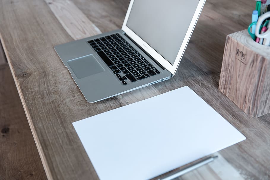 MacBook Pro on brown wooden table near pen organizer, MacBook Air HD wallpaper