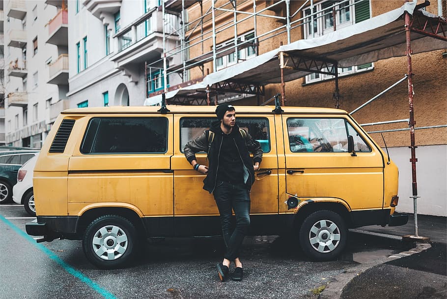 person leaning on yellow minivan parked near building, young HD wallpaper