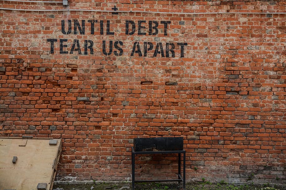 Until debt tear us apart printed red brick wall at daytime, brown brick wall with until debt tear us part text HD wallpaper