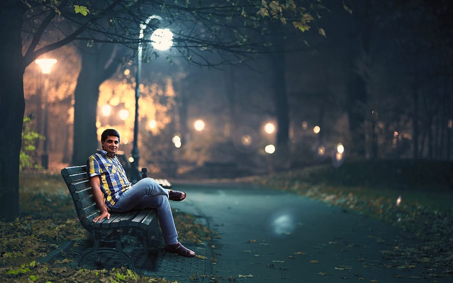man sitting on outdoor bench during night near light post, park light HD wallpaper