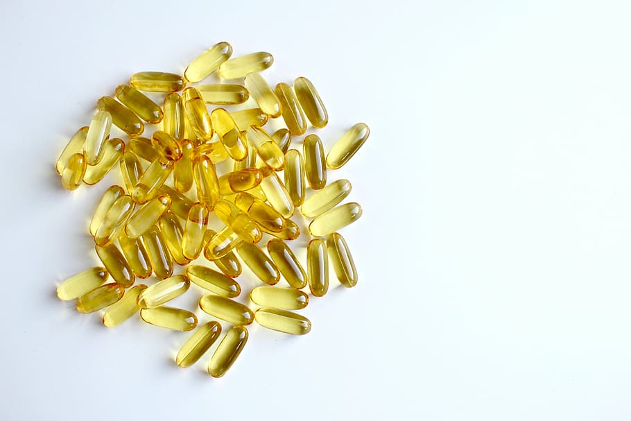gold pills on white surface, fish oil, capsule, yellow, oil capsule