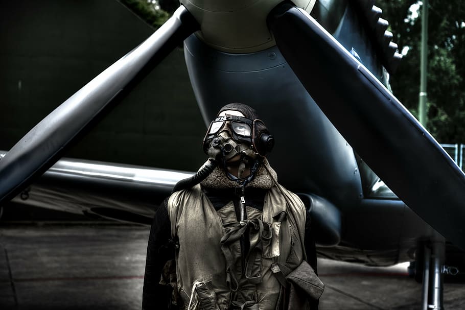man wearing mask and suit, pilot, standing, plane, airplane, jacket