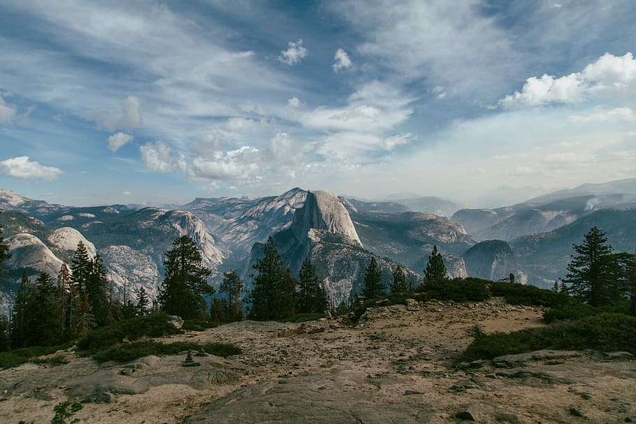 landscape photography of mountains near trees, landscape photography of mountains and trees under cloudy skies HD wallpaper