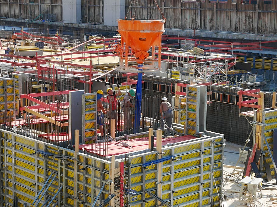 people working above yellow and red platform during daytime, construction site