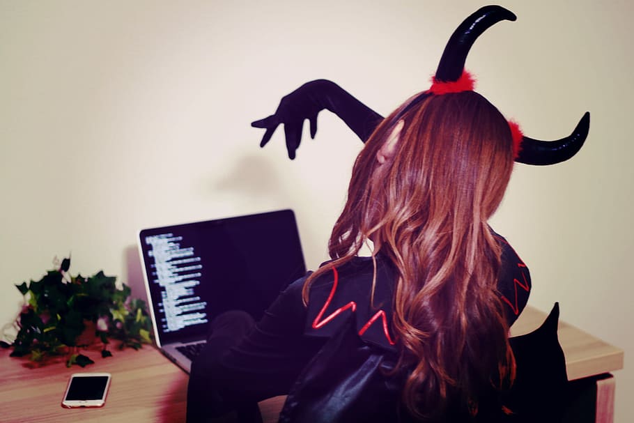 woman in black and red devil costume sitting in front of black laptop computer HD wallpaper