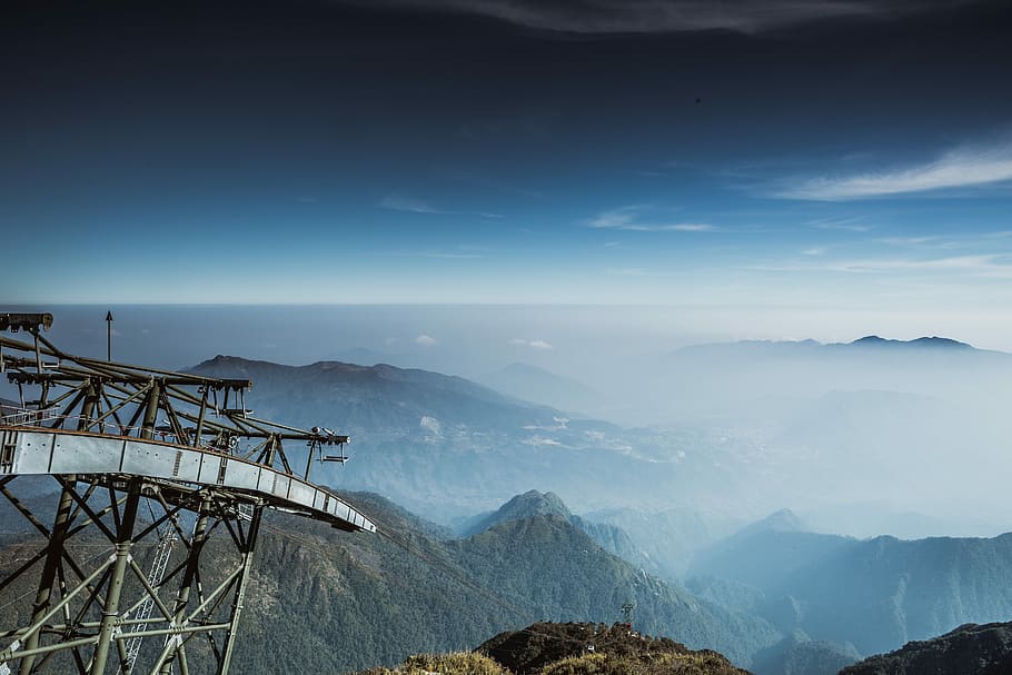 gray and brown bamboo structure near the mountains, aerial view photography of mountain covered by clouds during daytime HD wallpaper