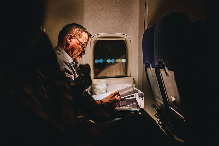 man reading book inside the plane, airplane, airline, travel