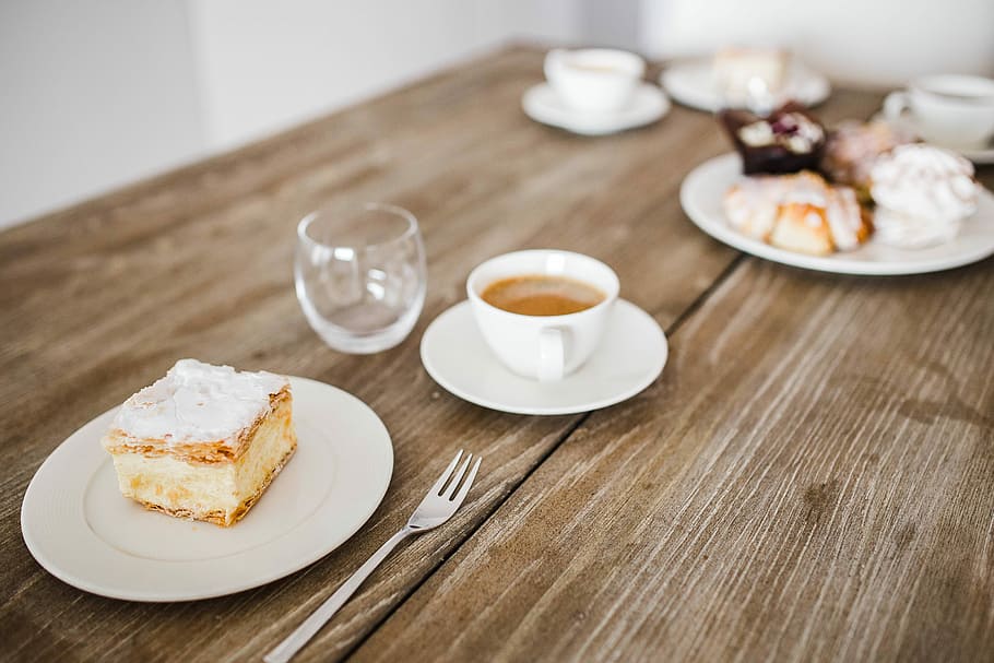 Sweet dessert with cream and a cup of coffee on a table, cake
