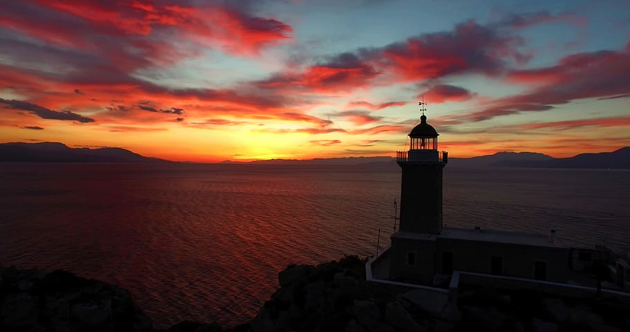 photo of lighthouse and a sunset, lighthouse near body of water during golden hour HD wallpaper