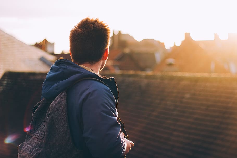 man facing on brown roof on rooftop, man carrying backpack looking at roof HD wallpaper