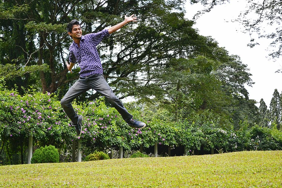 timelapse photography of man jumping on grasses, happy, happy mood