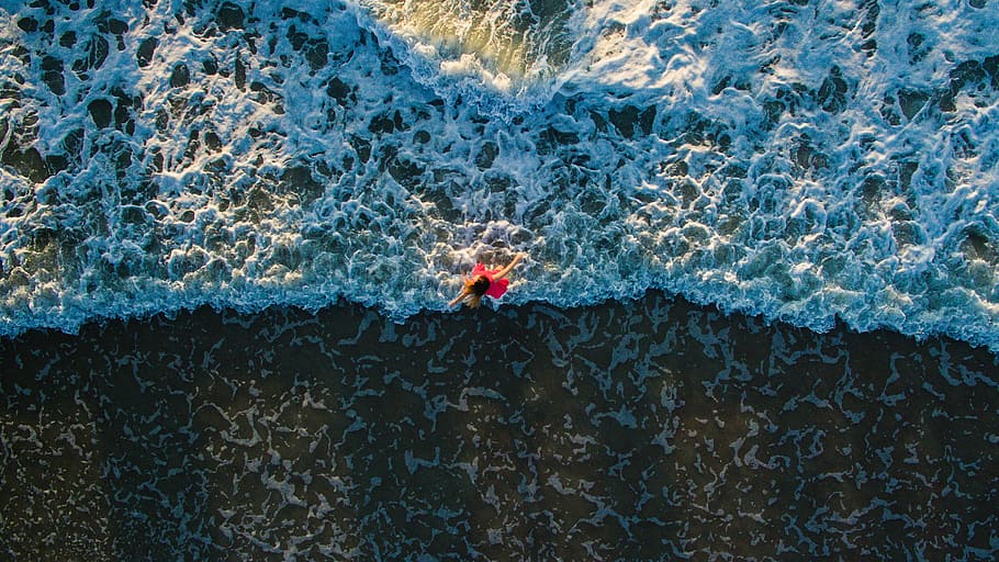 aerial photo of woman standing on shore, woman in red outfit on body of water HD wallpaper