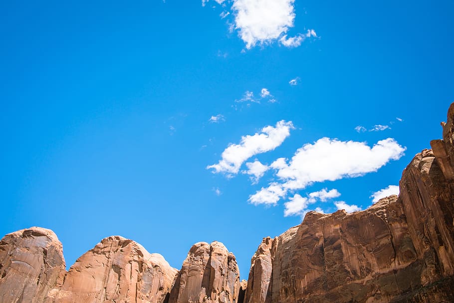 brown cliff under white and blue cloudy sky, cliff at daytime HD wallpaper