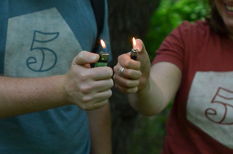 man and woman lit the two lighters they are holding, person lighter green disposable lighter HD wallpaper