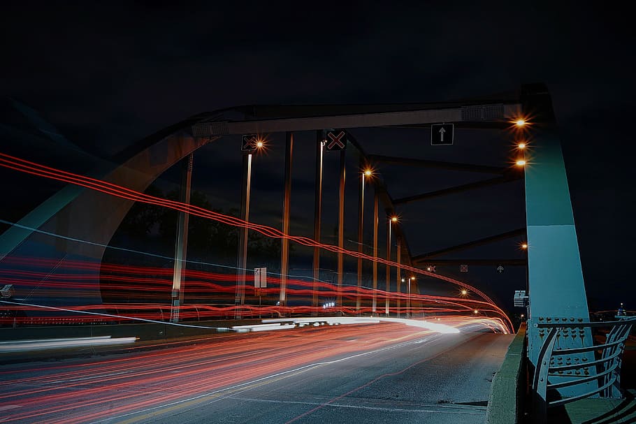 time lapse photography of road with arch, time lapse photo of gray bridge under dark sky HD wallpaper