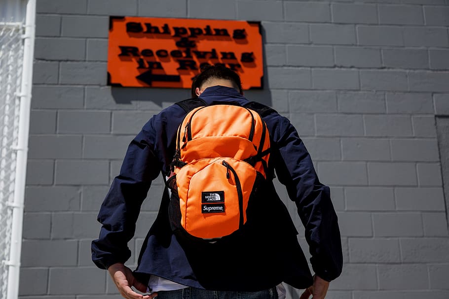 Shipping and Receiving in Rear, man standing in front of orange and black signage HD wallpaper